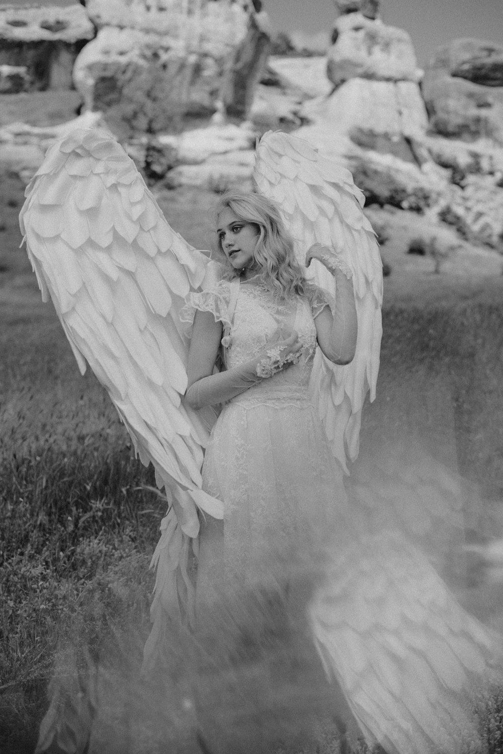 a woman in a white dress holding an angel wings