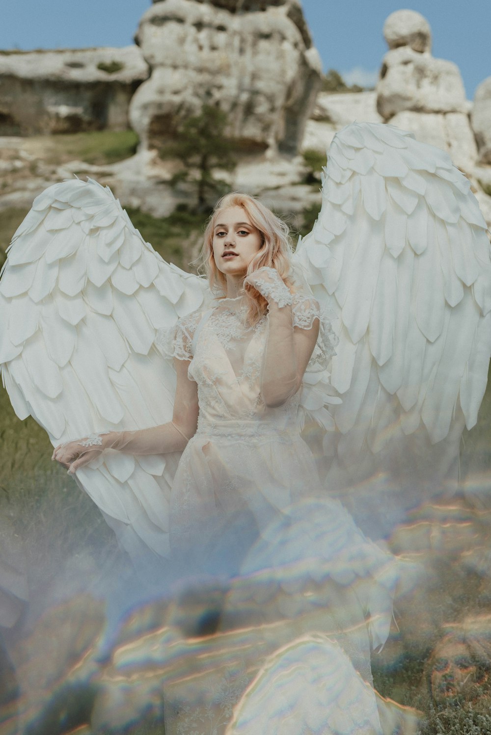 a woman in a white dress with angel wings