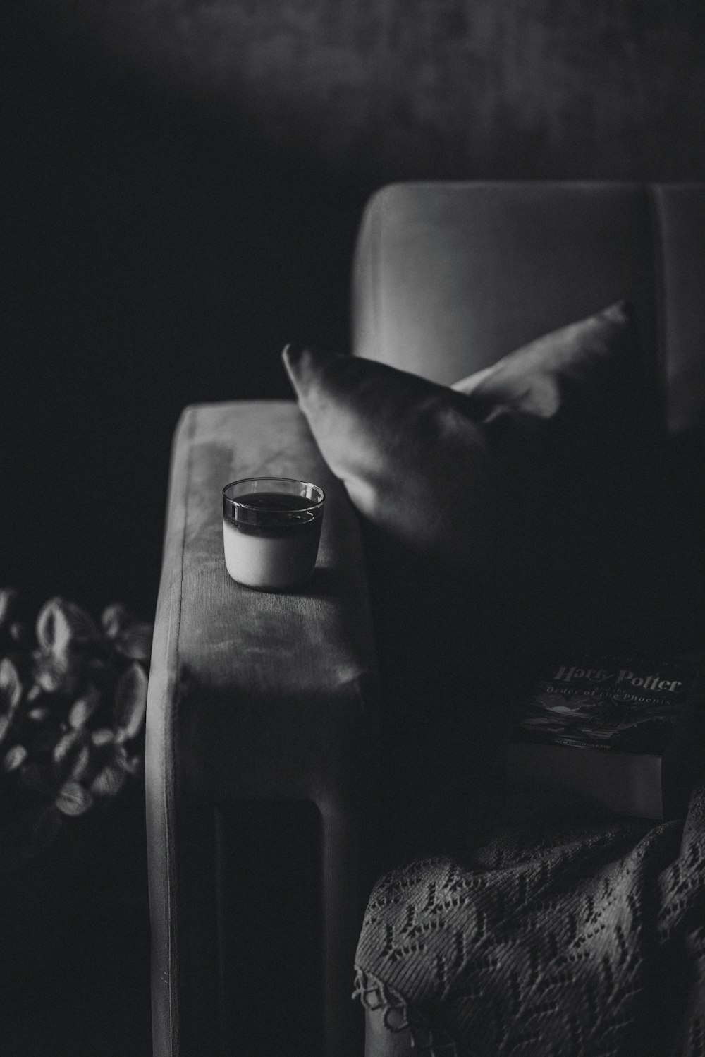 a black and white photo of a cup of coffee on a chair