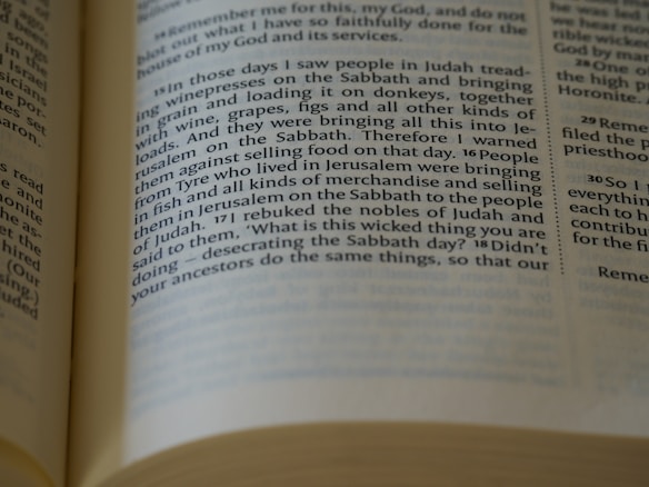 A close-up view of an open book showing a page with printed text in columns. The text focuses on historical and religious themes. The paper appears aged or off-white, suggesting it might be a religious or historical text. The edges of the pages are visible, and the lighting creates slight shadows across the page.