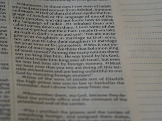 A close-up view of an open book page with printed text in English. The focus is on a particular section of text on the left, while the right side displays blank lines for note-taking.