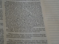 A close-up of an open English textbook with notes and a pen on a desk.