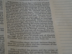 A close-up view of an open book page with printed text in English. The focus is on a particular section of text on the left, while the right side displays blank lines for note-taking.