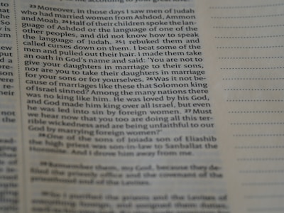 A close-up of an open English textbook with notes and a pen on a desk.