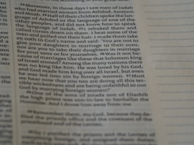 A close-up view of an open book page with printed text in English. The focus is on a particular section of text on the left, while the right side displays blank lines for note-taking.