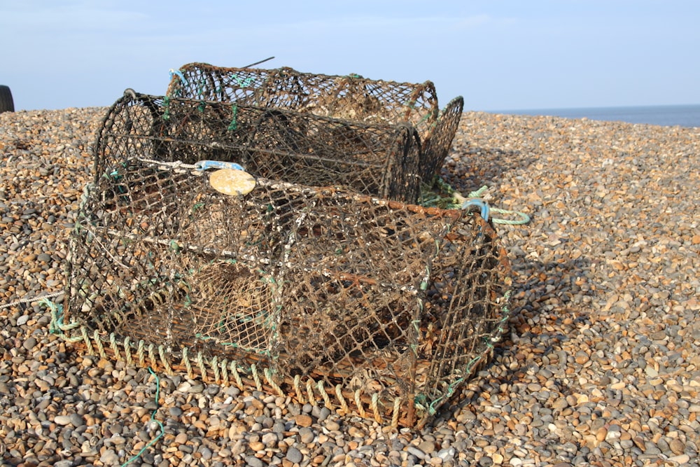 a pile of lobster traps sitting on top of a rocky beach