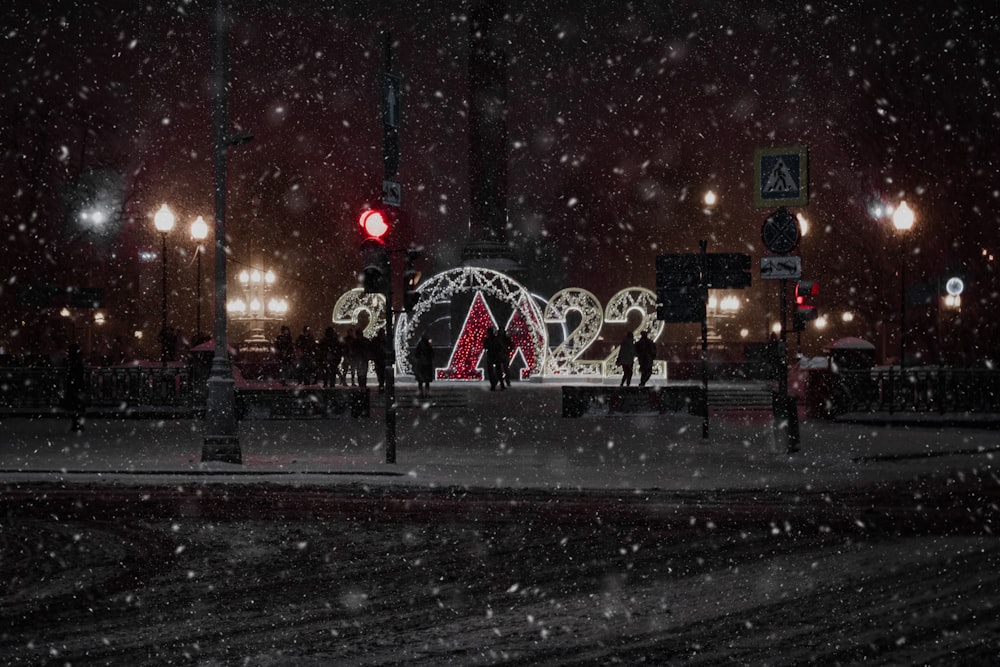 Un semaforo rosso seduto sul lato di una strada coperta di neve
