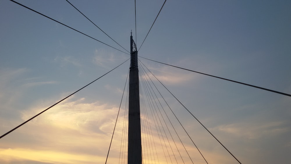 the top of a tall pole with power lines above it