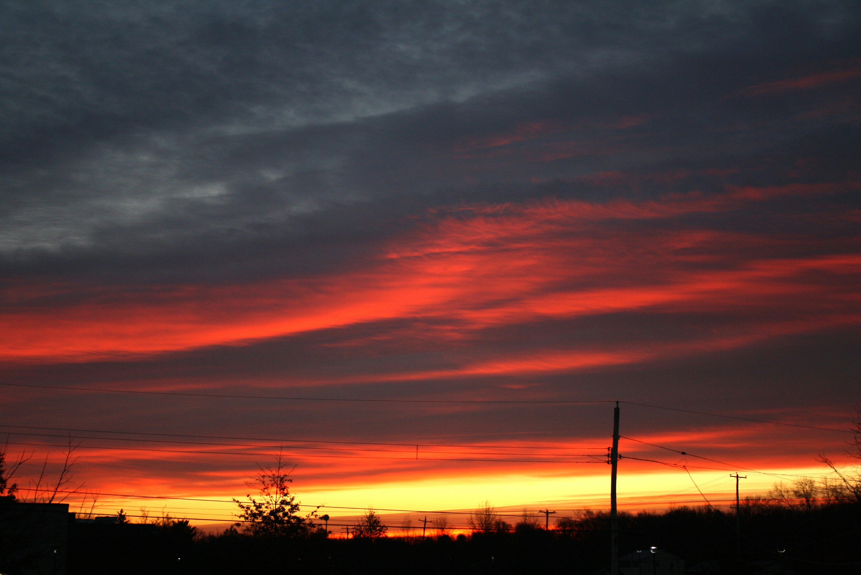 a red and yellow sunset with clouds in the sky