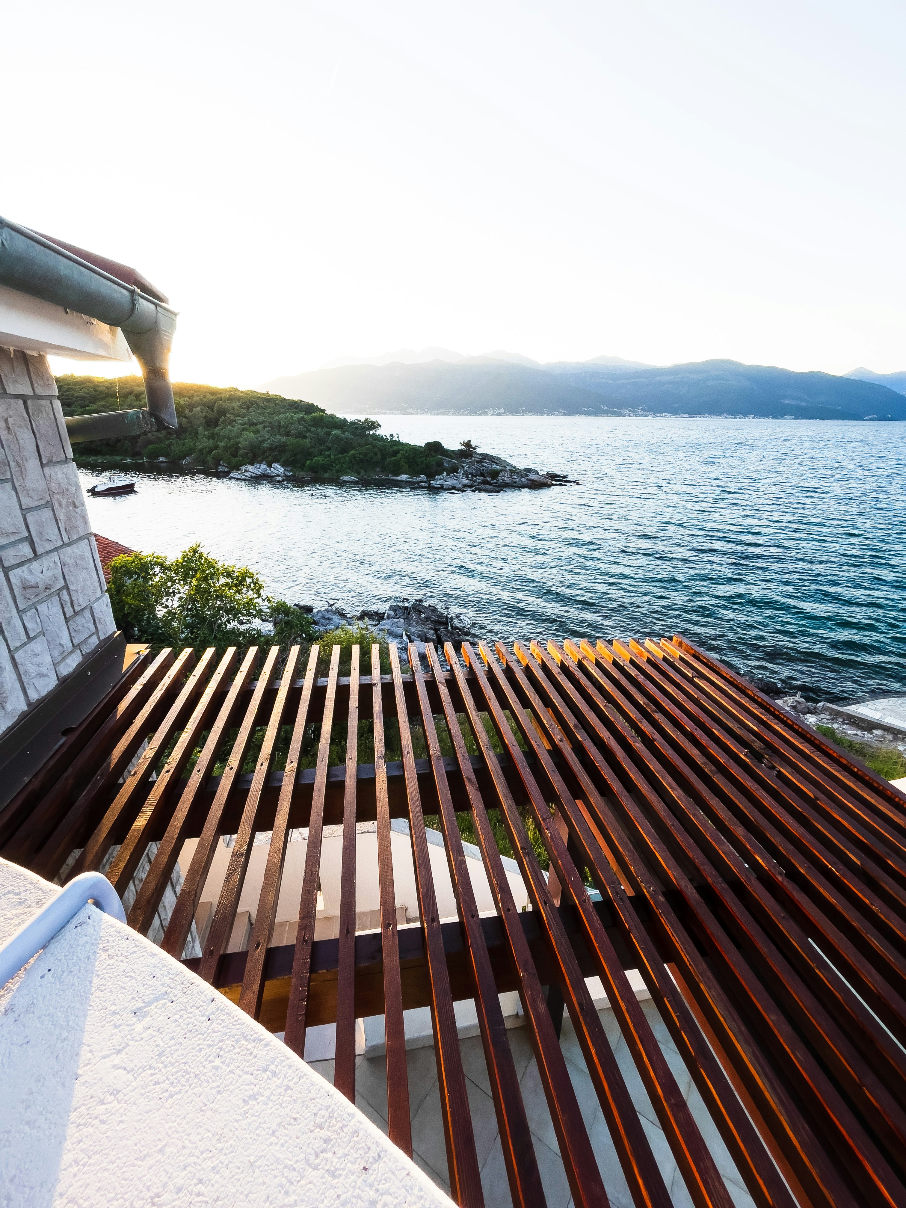 A wooden bench sitting next to a body of water photo – Free Черногория ...