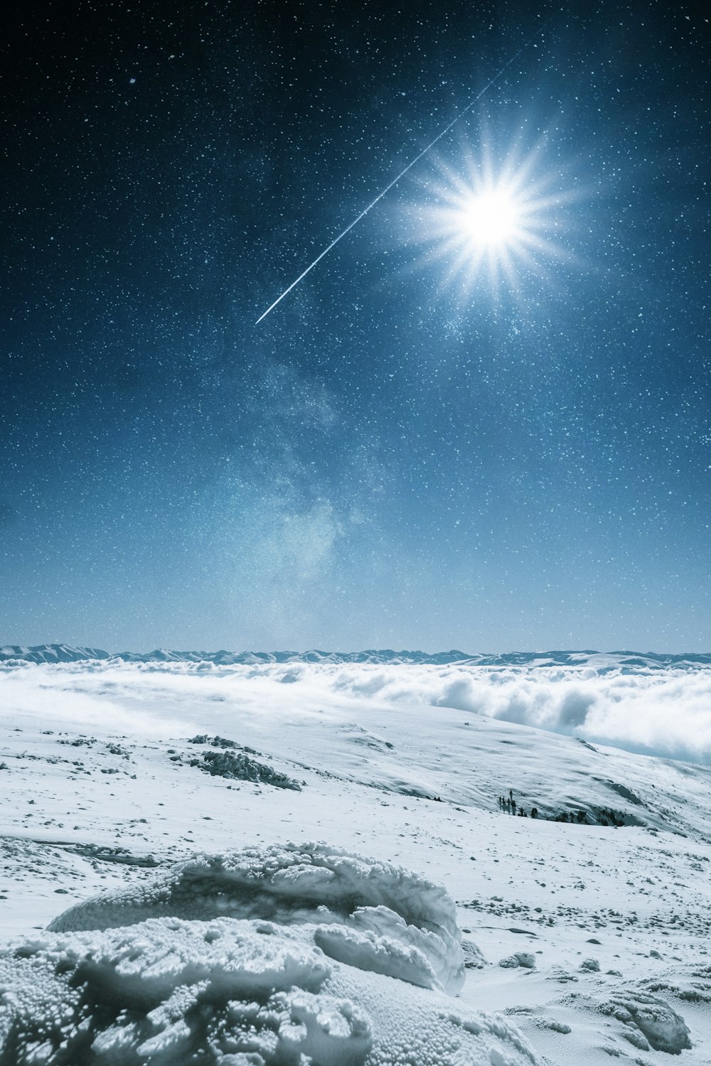 a bright star shines above a snowy landscape
