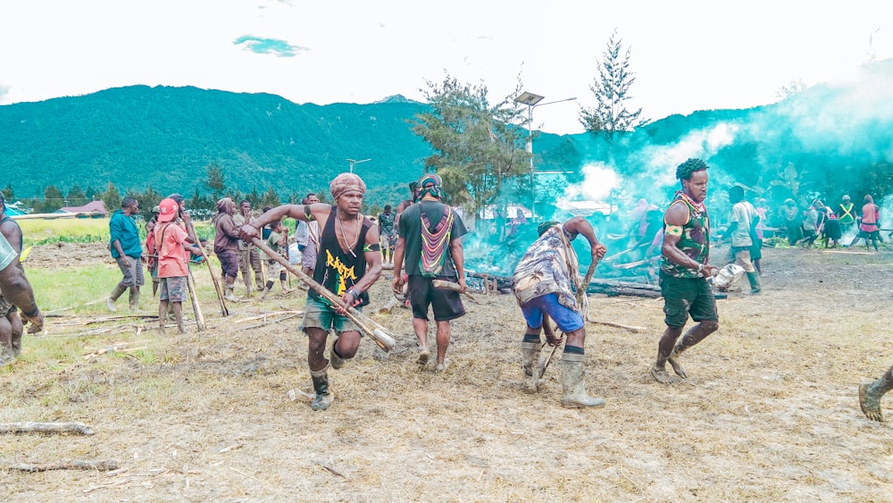 a group of people walking across a dirt field