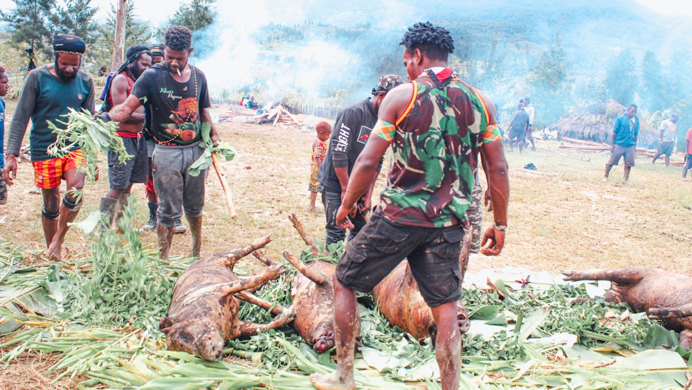 a group of men standing around a pile of dead animals