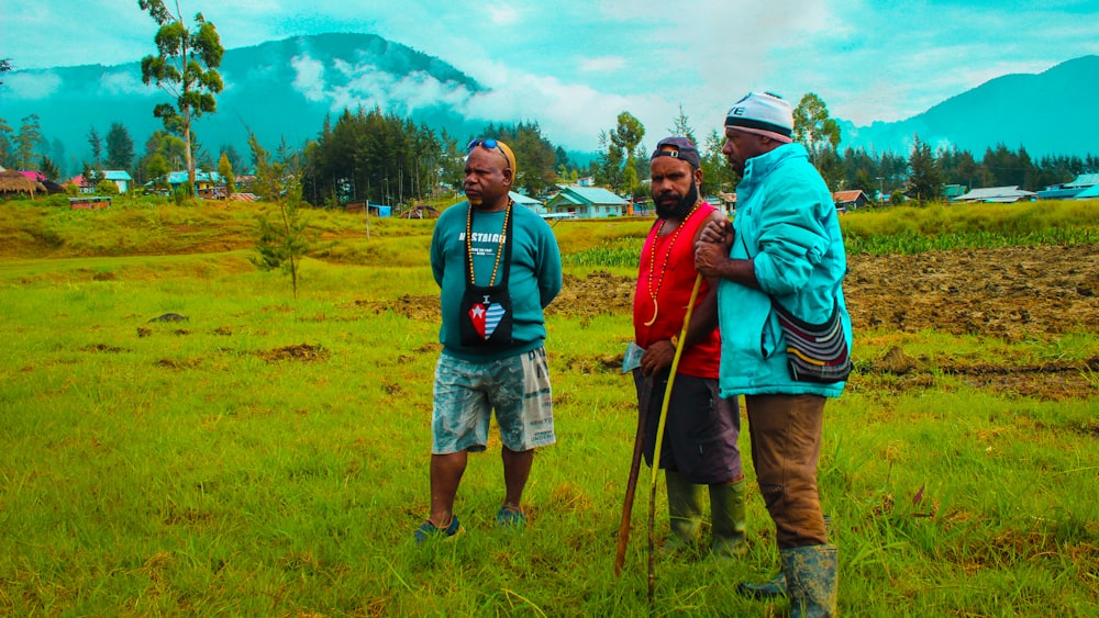 a group of men standing on top of a lush green field