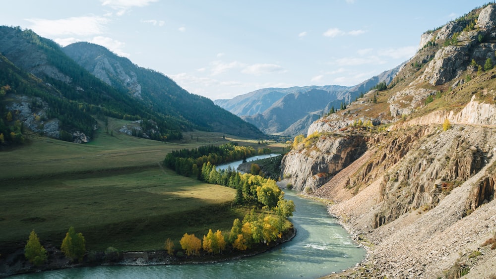 a river running through a valley surrounded by mountains