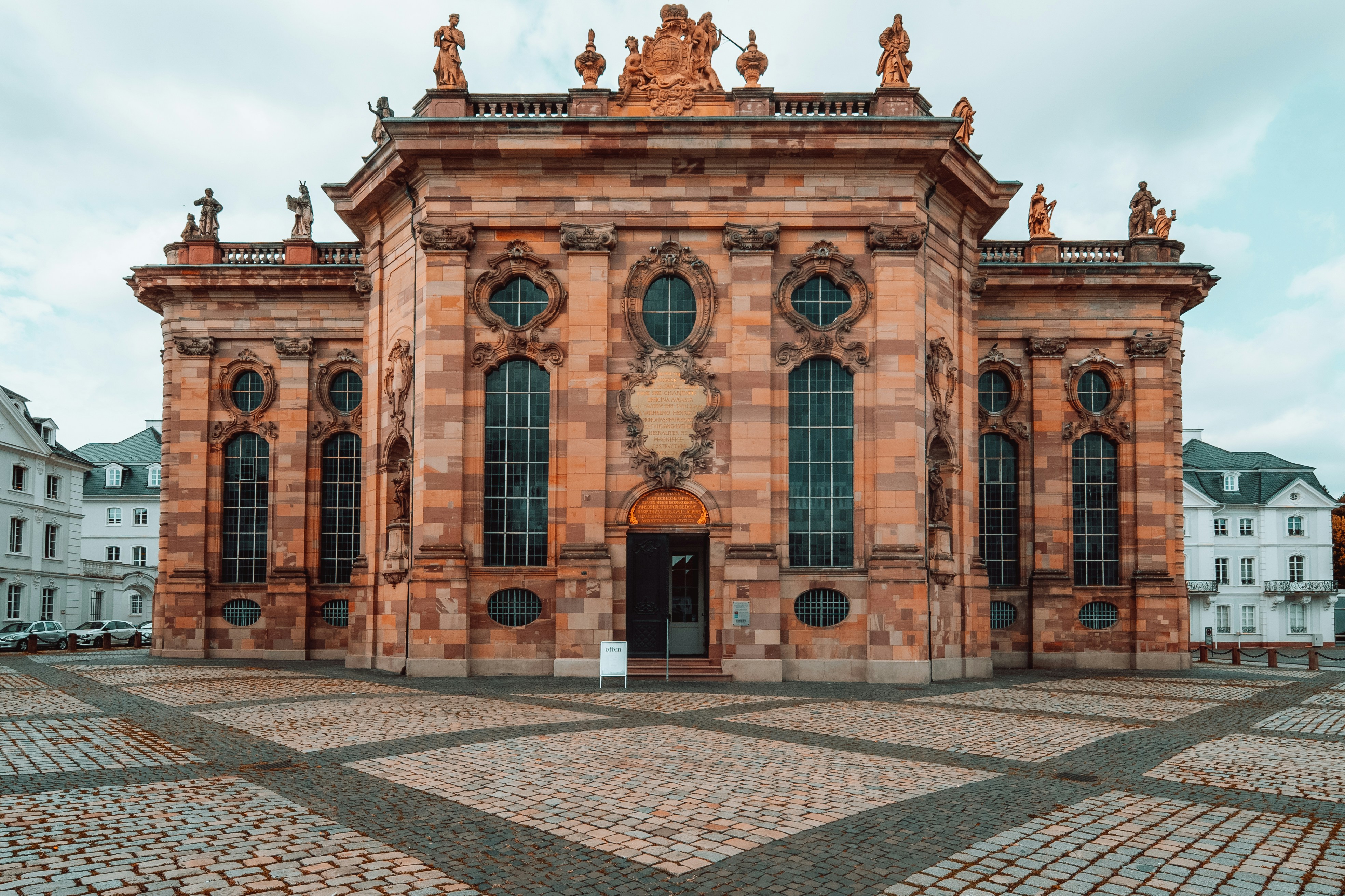 a large building with many windows and statues on top of it