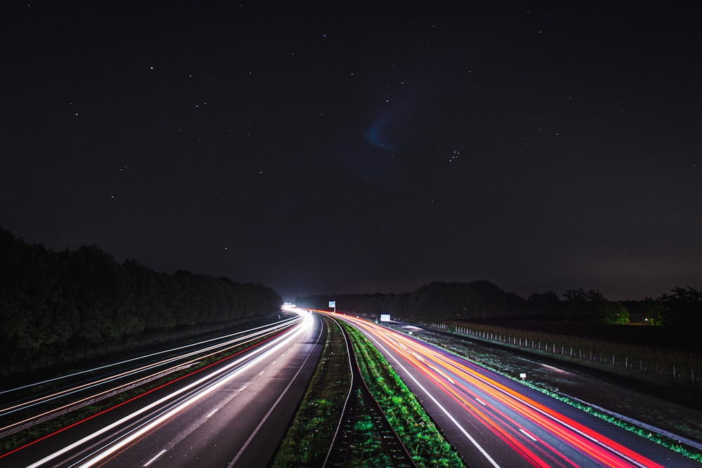 a long exposure photo of a highway at night