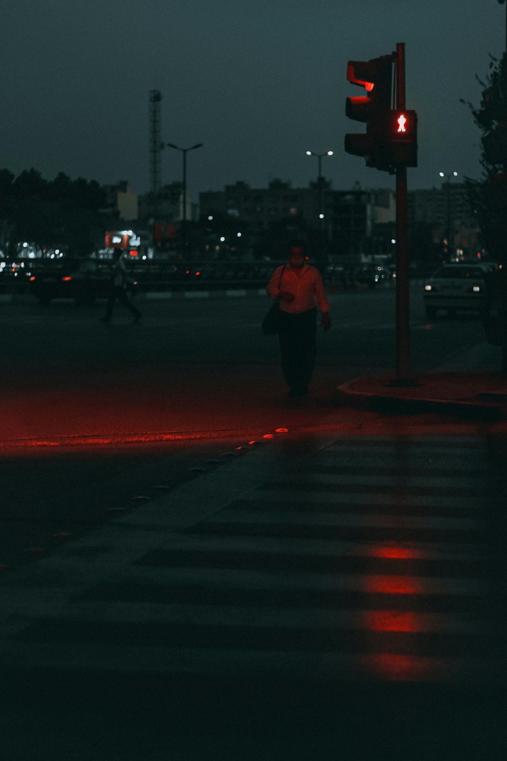 a person walking across a street at night