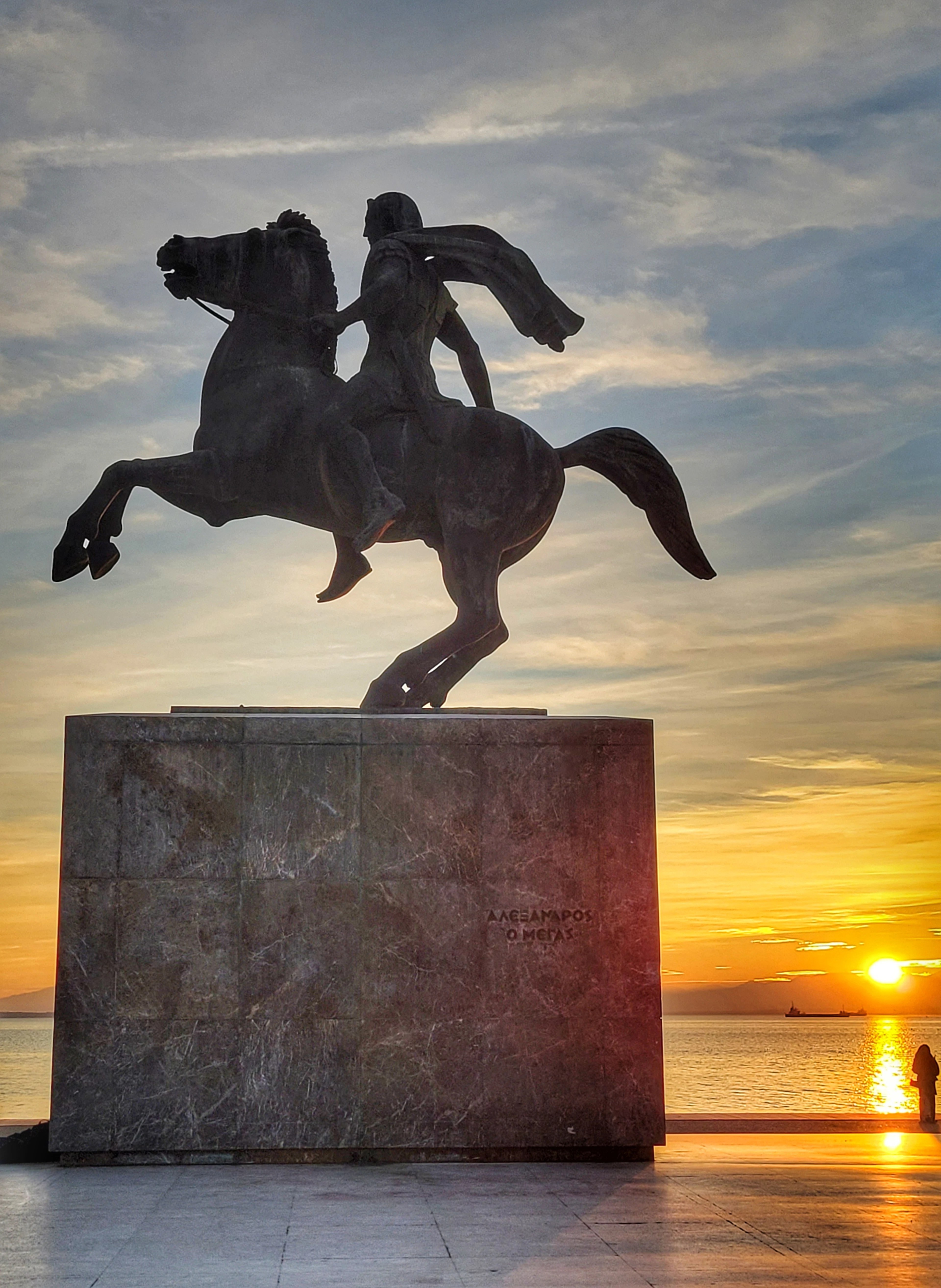 The statue of Alexander the Great on Thessaloniki's waterfront promenade at sunset, with the Thermaic Gulf glowing behind