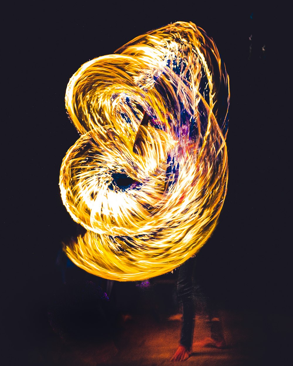 a person is spinning fire in the dark