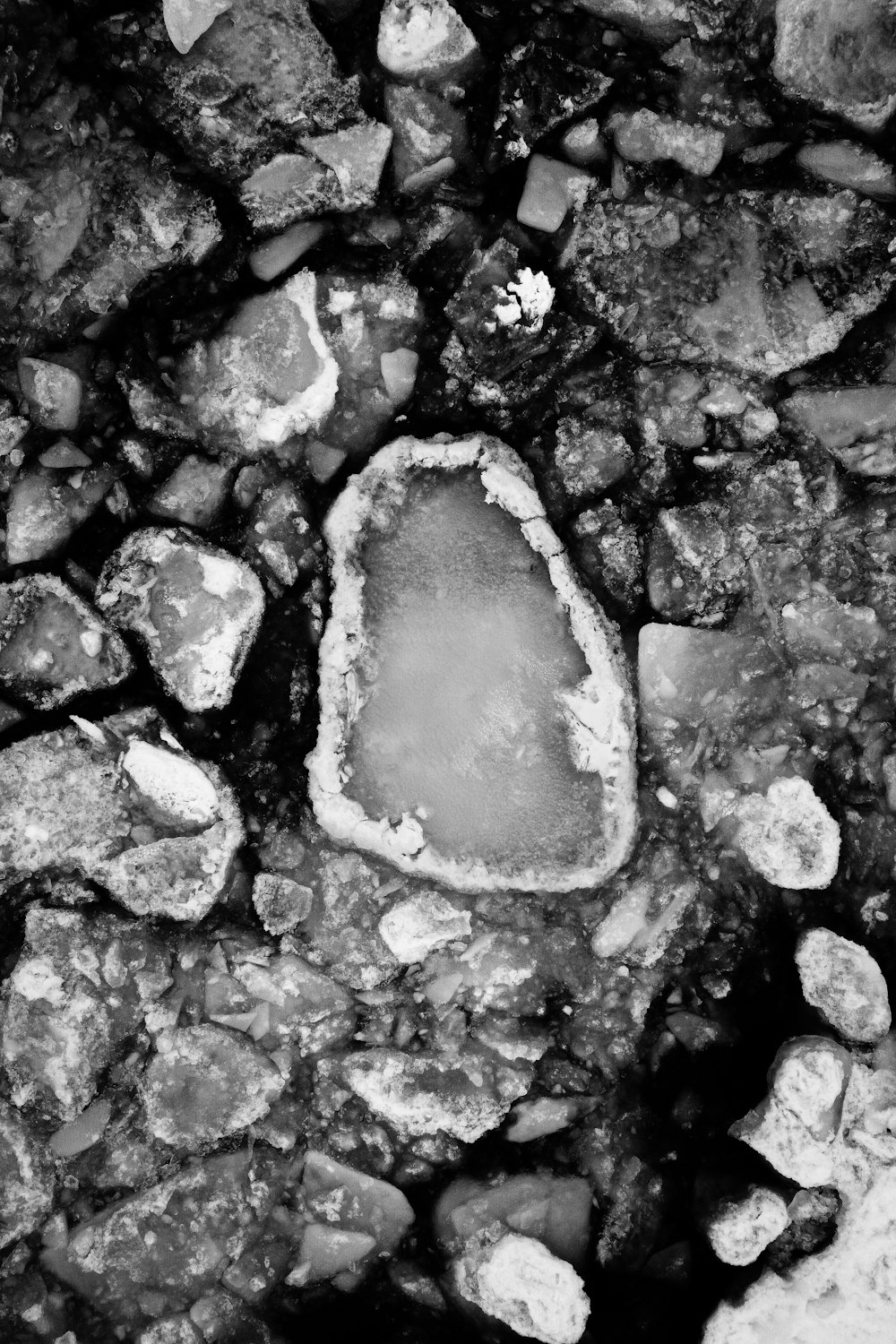 a black and white photo of rocks and water