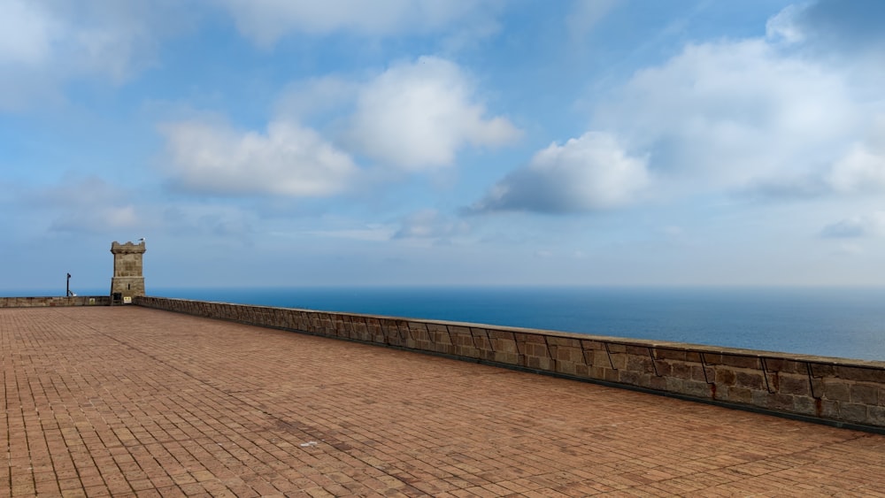 a brick walkway with a clock tower in the distance