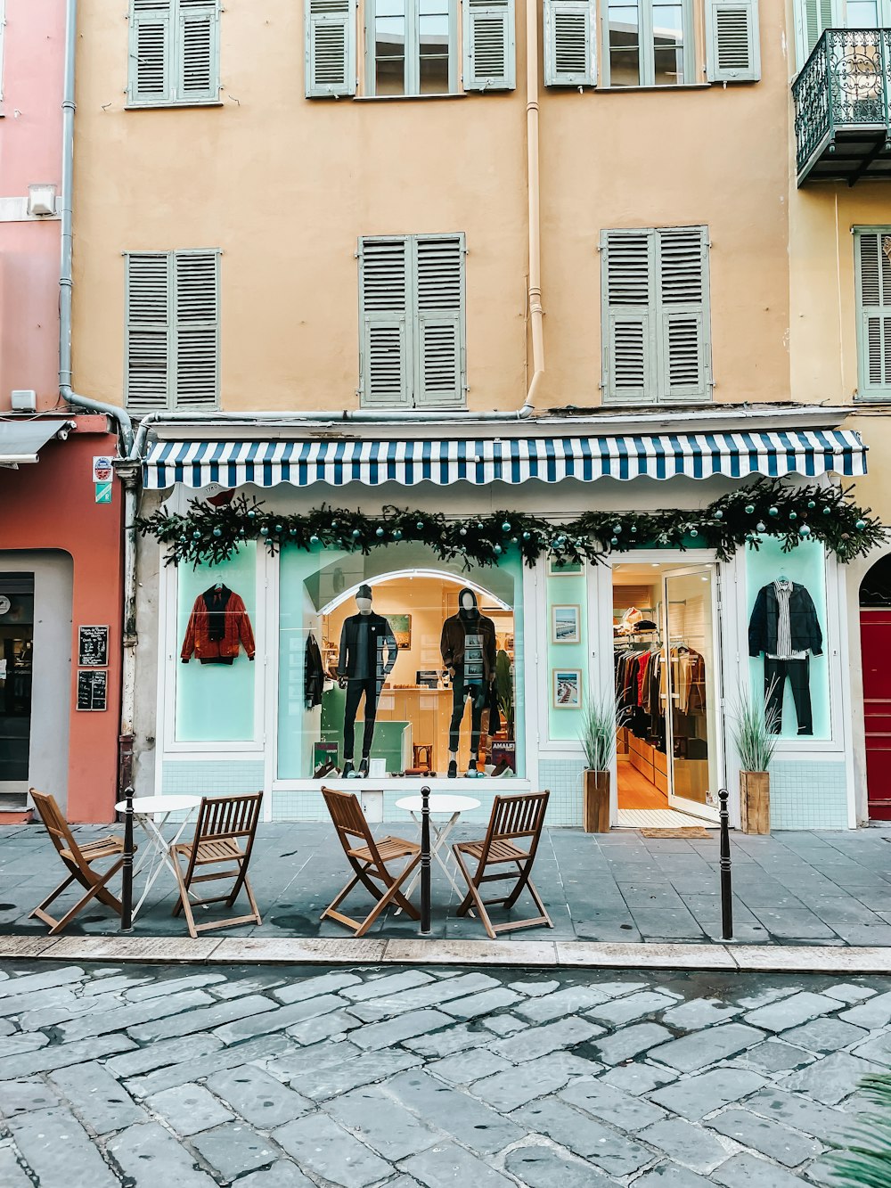 a couple of wooden chairs sitting in front of a store