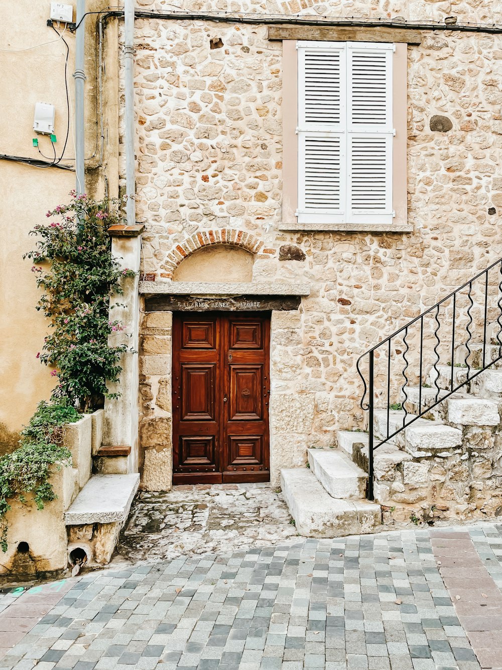 a stone building with a wooden door and stairs