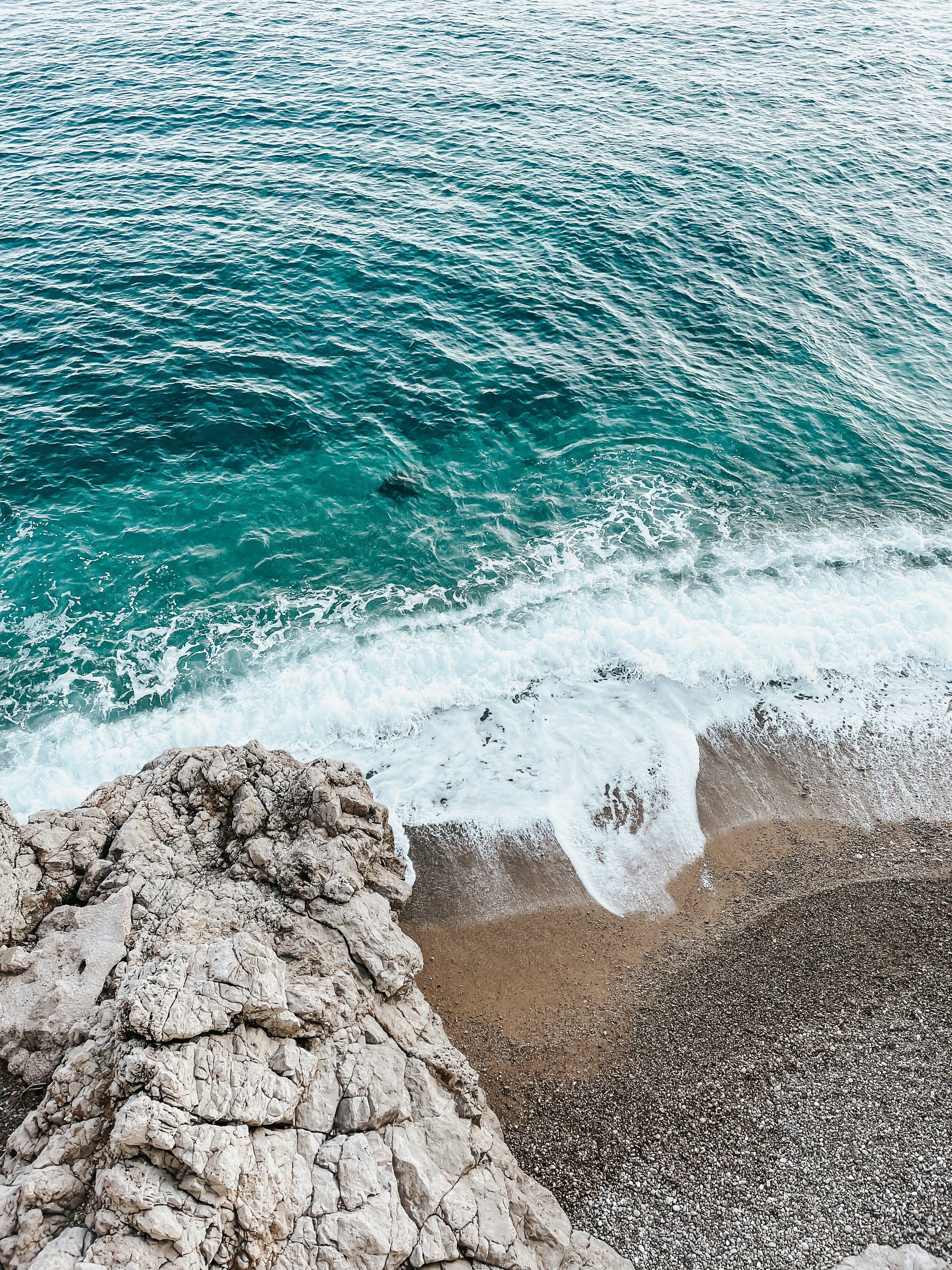 a body of water sitting next to a rocky shore