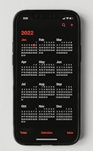 A calendar with marked corporate event dates alongside a smartphone displaying notifications.