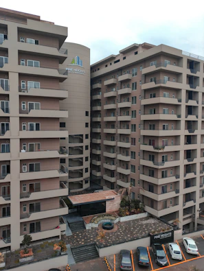 Modern 3 BHK apartment exterior with large windows and landscaped surroundings.
