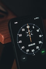 a close up of a clock on a wooden table