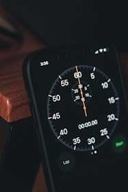 a close up of a clock on a wooden table
