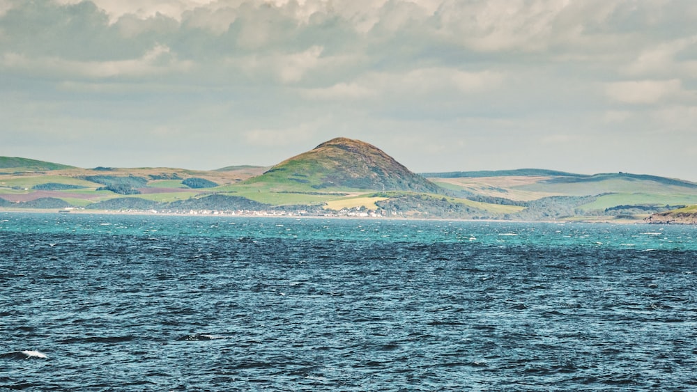 a large body of water with a mountain in the background