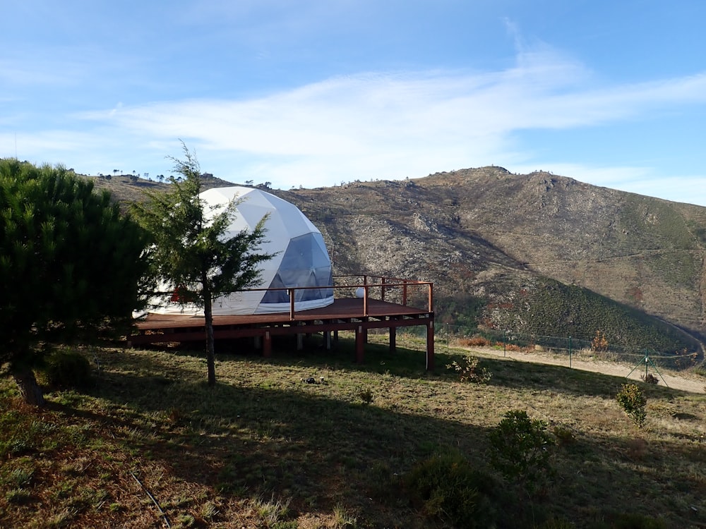 a white dome sitting on top of a lush green hillside