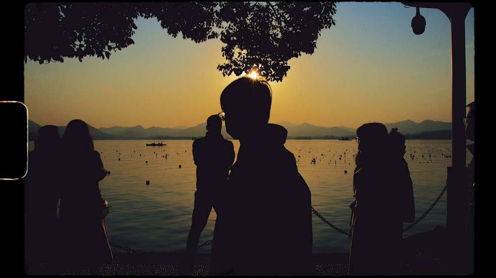 a group of people standing next to each other near a body of water