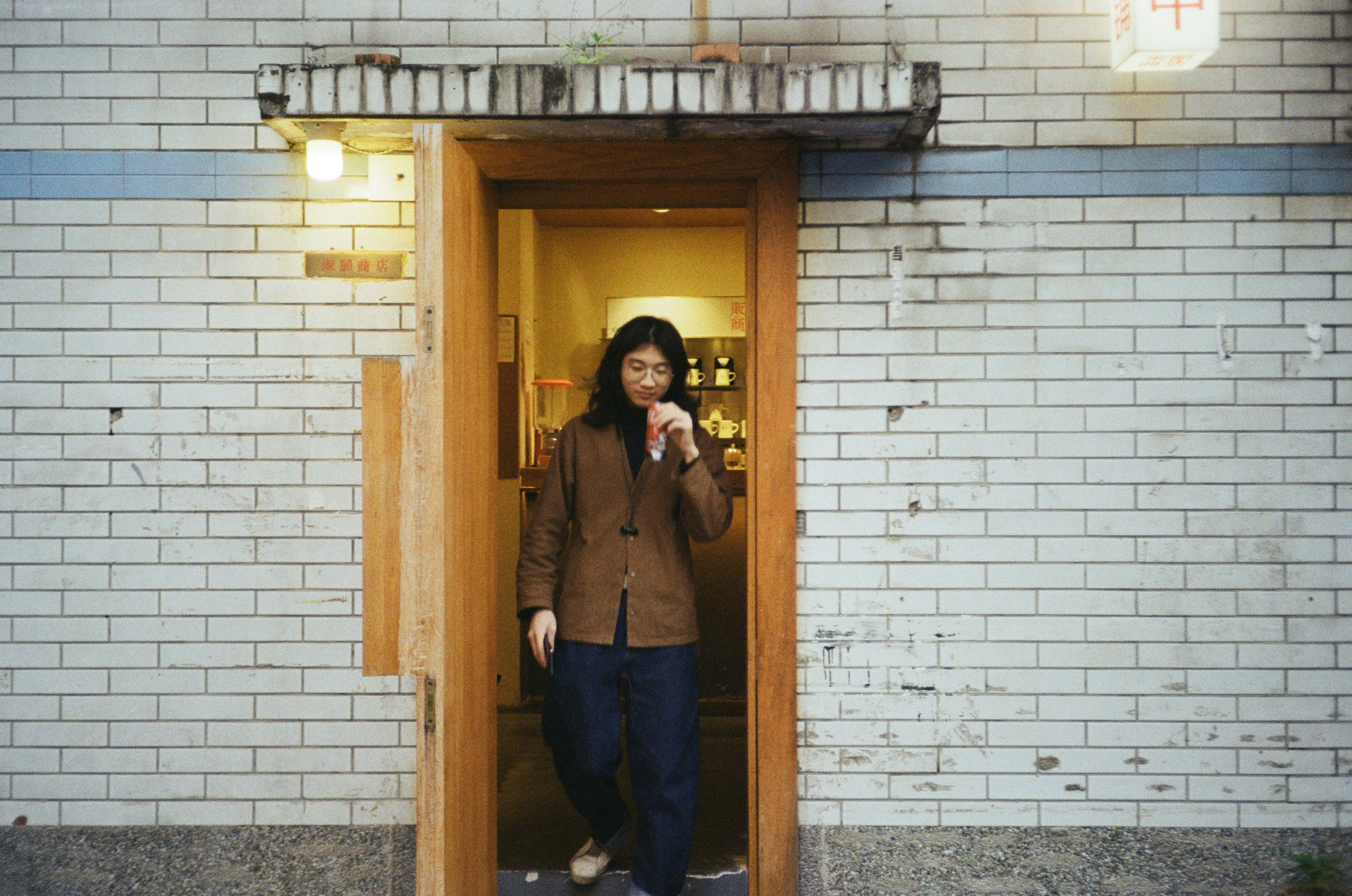 A Woman Standing In A Doorway Of A Building