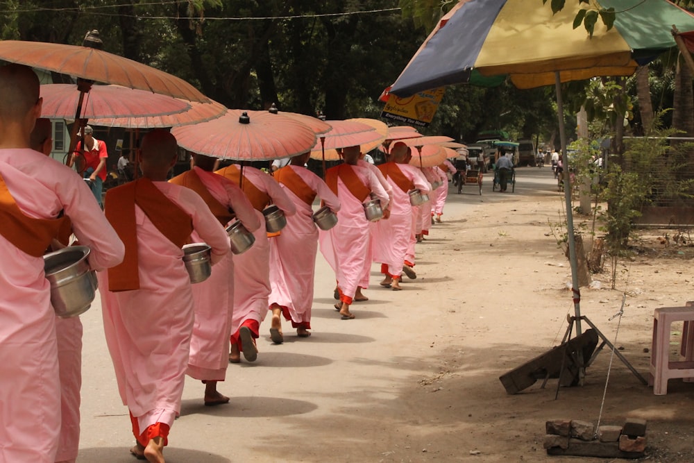 a group of people walking down a street holding umbrellas