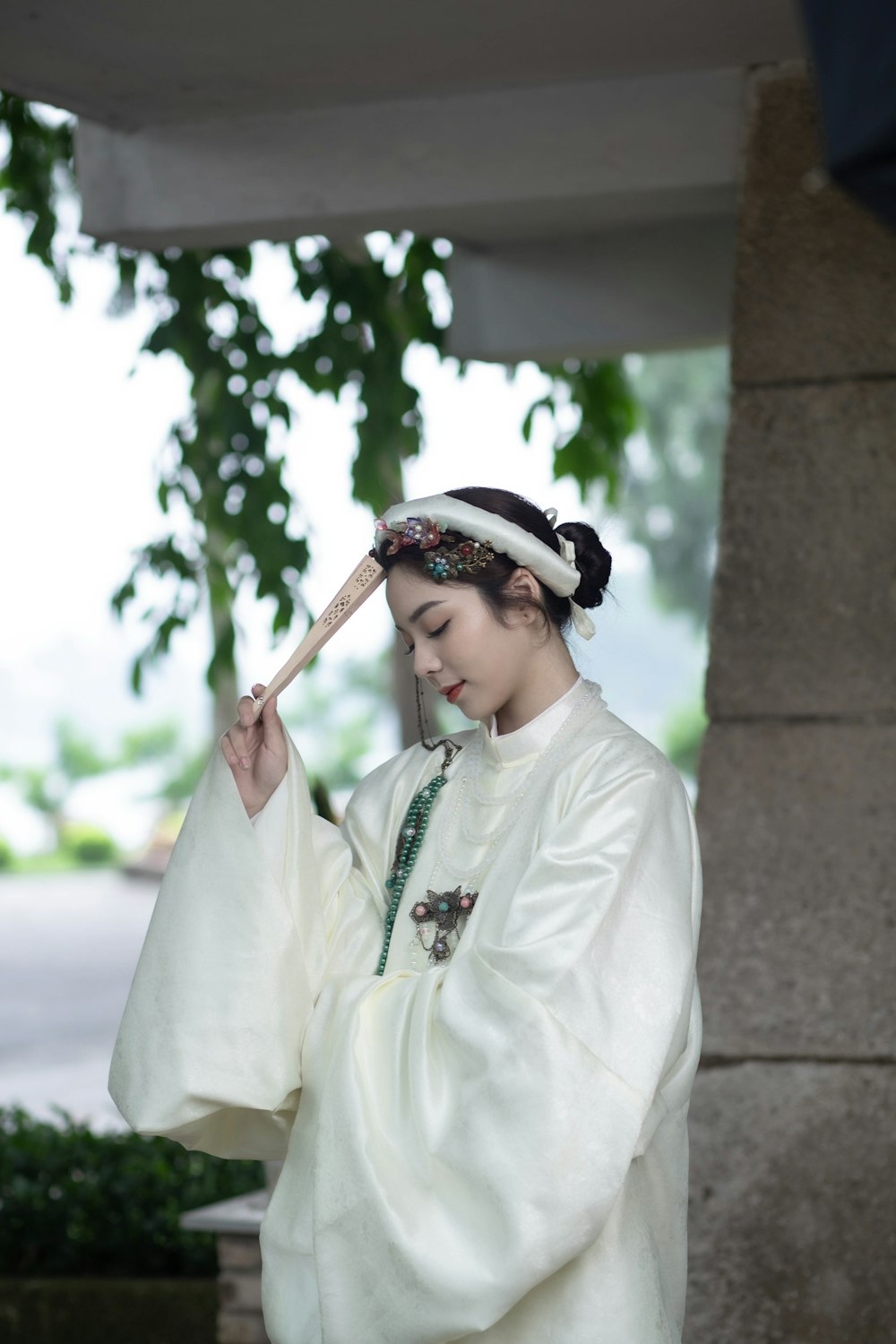 a woman in a white dress holding a bamboo stick