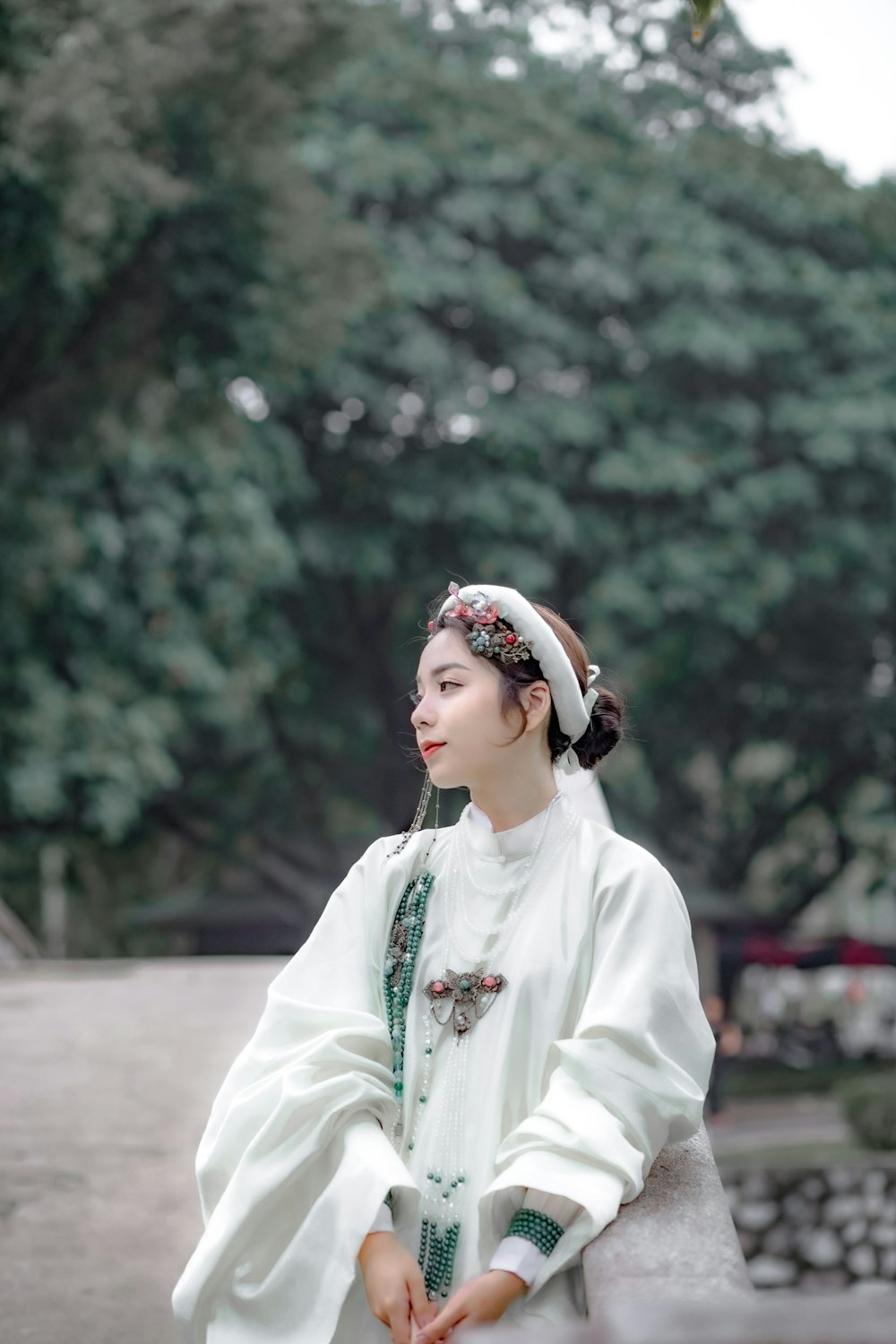 a woman in a white dress sitting on a bench