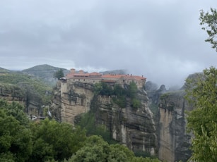 a village perched on a cliff surrounded by trees