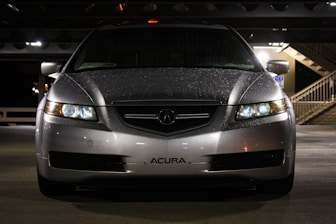 a silver acura car parked in a parking garage