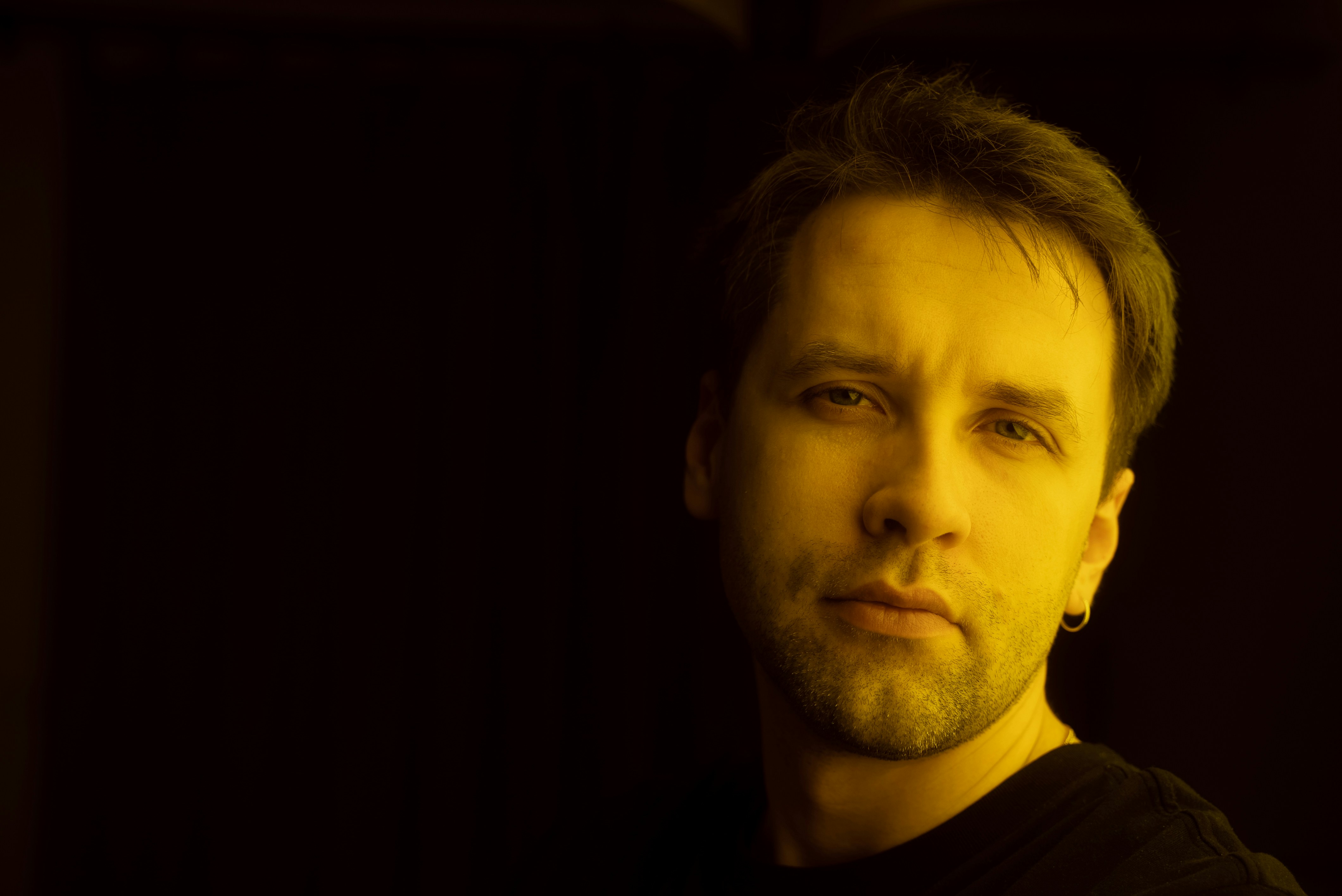 a man in a black shirt looking at the camera