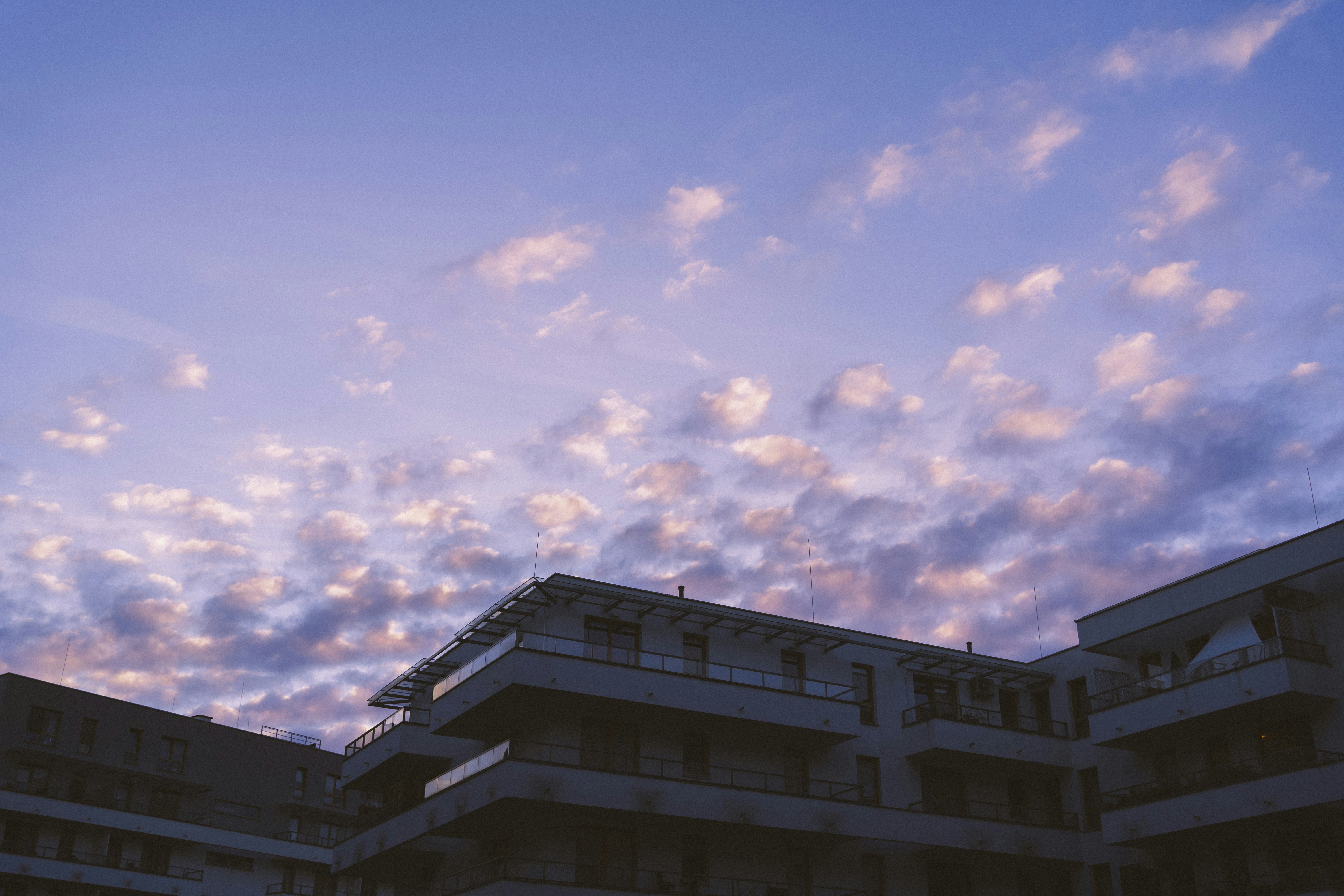 a building with balconies and balconies against a cloudy sky