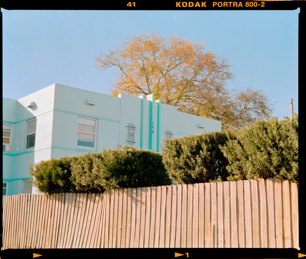 a white building sitting on top of a wooden fence