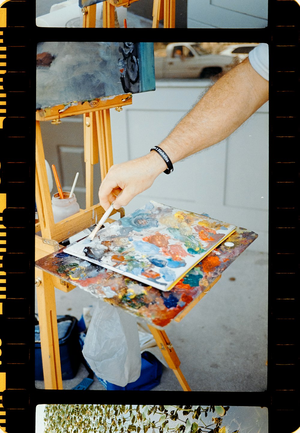 a man is painting a picture on an easel