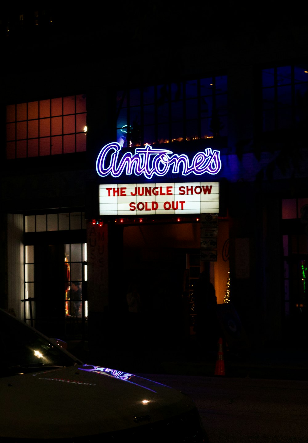 a neon sign is lit up on the side of a building