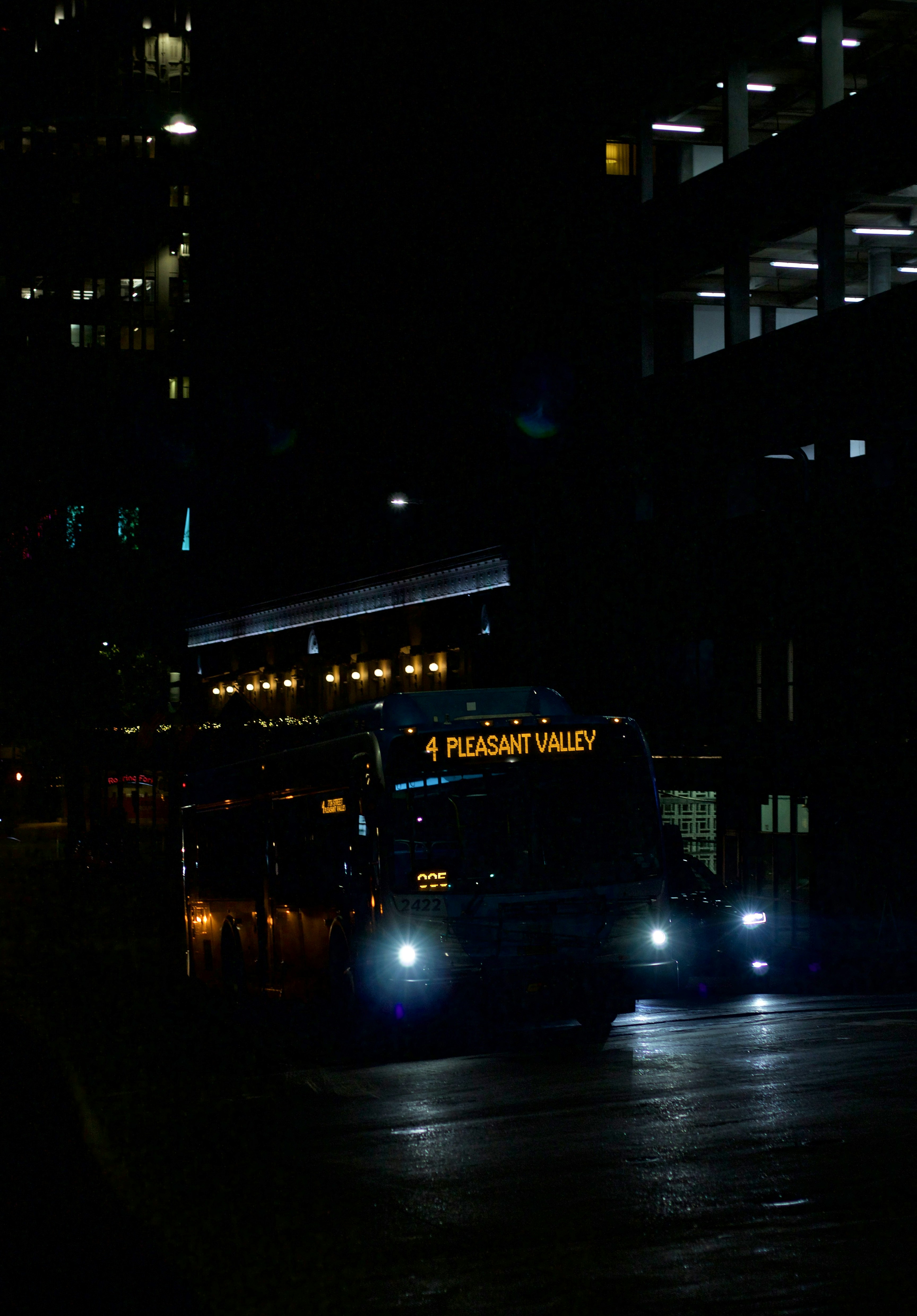 a bus driving down a street at night