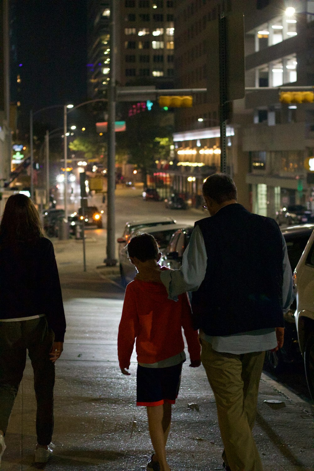um grupo de pessoas andando por uma rua à noite