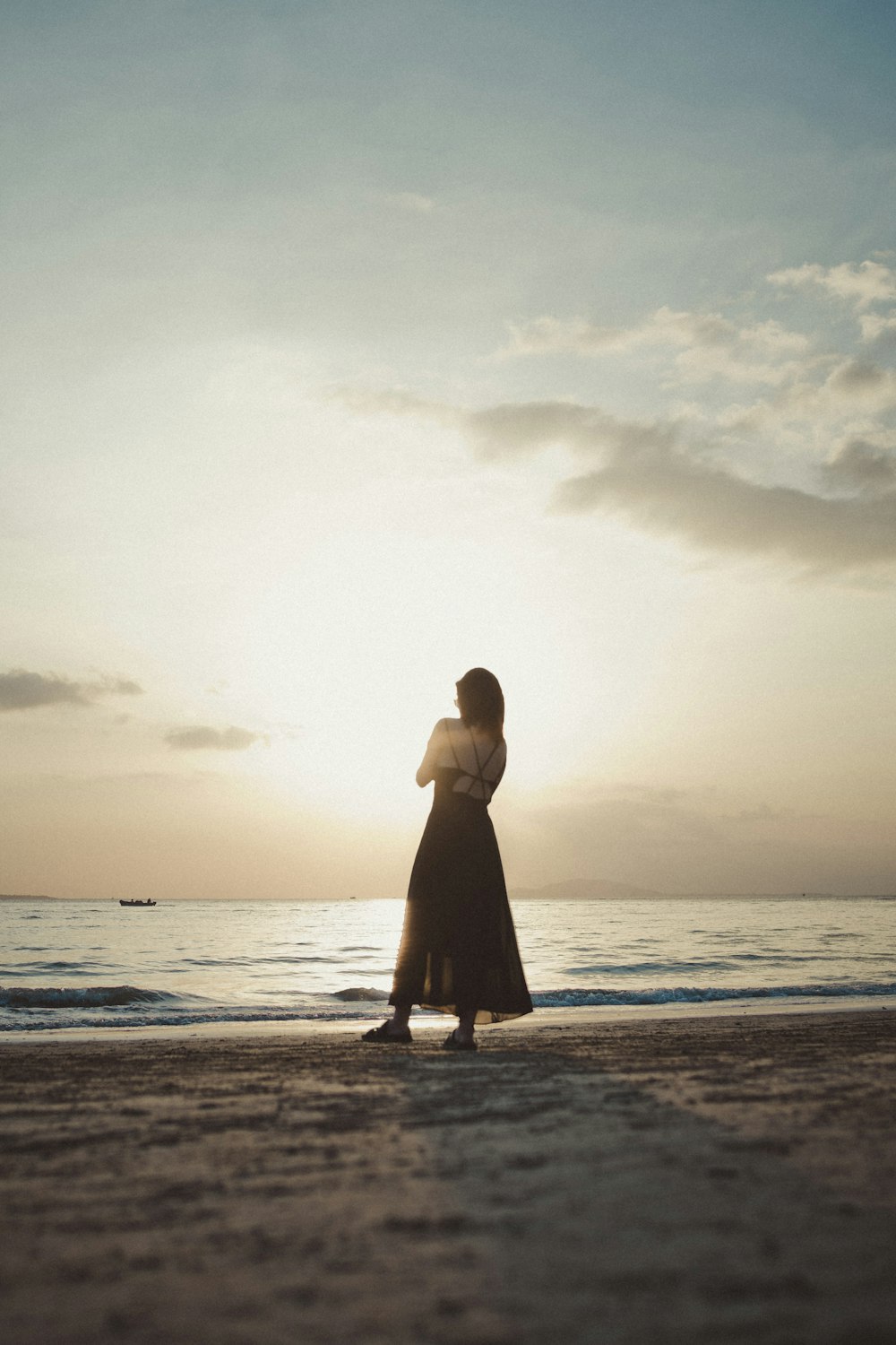 a woman standing on top of a sandy beach